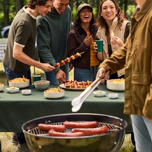 Friends at an Eckrich tailgate grilling smoked sausage and skewers