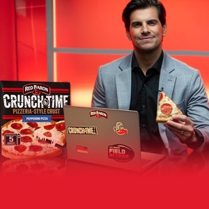 Fantasy football analyst Field Yates holding a slice next to a RED BARON CRUNCHTIME pizza box